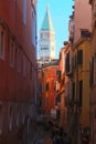 glimpse of the bell tower of Saint Mark in Venice and the navigable canal among the houses