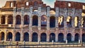 Glimpse of Colosseum in a summer evening with tourists enjoying the beauties of Rome