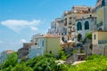 Glimpse of houses perched on a hill, with blue sky as a background