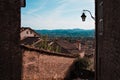 A glimpse of the medieval village of Gubbio from an alley with stone houses and a street lantern hanging on a wall Umbria, Italy