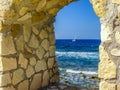 A glimpse of the Mediterranean framed by an arch in  sea wall of Chania harbour, Crete on a bright sunny day Royalty Free Stock Photo
