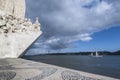 Glimpse of the monument to the discoveries and bridge 25 April on the river Tagus in Lisbon Royalty Free Stock Photo