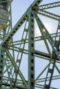 Glint of sunlight on the intertwining openwork trusses of the metal drawbridge