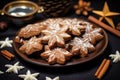 glistening cinnamon star biscuits with almonds on a dark wooden plate