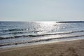 Glistening waves roll onto the shoreline of the beach