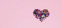 Glitter confetti heart on pink background. Love romance passion symbol