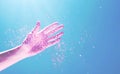 Glitter falling on women hand from above on blue background. Neon pink visual escapism, vibrant surreal world