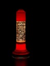 Glitter lava lamp on black background. Genuine vintage 1970 edition, red orange colour.