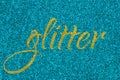 Glitter lettering word gold on cyan blue sparkle texture. Shiny background