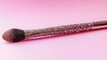 Sparkling Glitter Makeup Brush on Pink Background Royalty Free Stock Photo