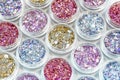 Glitter for manicure, makeup, nail extension, design. Cosmetic products. Shimmer in jars on white background. Royalty Free Stock Photo