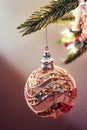 Glitter and mesh Christmas gold and pink ornament hanging from tree