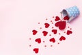 Glitter paper hearts pouring out of decorative iron bucket a pink background. Happy Valentine`s Day Flat lay Top view