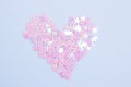 Glitter pink stars in a shape of heart on a light blue background. Love concept