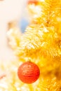 Glittering Bauble with Glowing Sparkling Gold defocused Light bokeh Illumination background with decorated Christmas Tree. Royalty Free Stock Photo