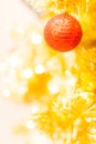 Glittering Bauble with Glowing Sparkling Gold defocused Light bokeh Illumination background with decorated Christmas Tree. Royalty Free Stock Photo