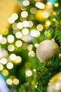 Glittering Baubles with Glowing Sparkling Gold defocused Light bokeh Illumination background with decorated Christmas Tree. Royalty Free Stock Photo