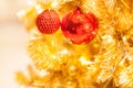 Glittering Baubles with Glowing Sparkling Gold defocused Light bokeh Illumination background with decorated Christmas Tree. Royalty Free Stock Photo