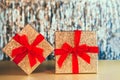 Glittering golden gift boxes with velvet red ribbon with a bow on the sparkling gold tinsel background. The concept Royalty Free Stock Photo