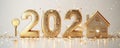 Golden house key alongside shimmering numbers 2024 on a snowy surface, symbolizing new beginnings and home ownership for Royalty Free Stock Photo