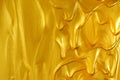 Glittering shiny metallic gold paint flowing and dripping downward making a golden background with empty copyspace