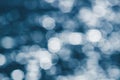 Glittering silver bokeh on surface of blue water Royalty Free Stock Photo