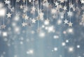 Glittering silver stars suspended against a soft blue bokeh background Royalty Free Stock Photo