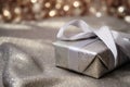 a glittering silver wrapped present box on a plain burlap fabric