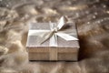 a glittering silver wrapped present box on a plain burlap fabric
