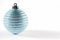 A glittery blue Christmas ball on a white background