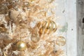 Glittery gold Christmas ornaments on a gold artificial tree