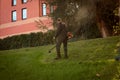 Globa Park, Dnepropetrovsk, Ukraine - 10/15/2020: Autumn work in the park. The gardener cuts the grass before winter