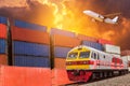 Global business with commercial cargo freight train and container cargo stack at the dock during cargo plane flying above on sunse Royalty Free Stock Photo