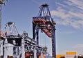 Crane lifting heavy cargo into a container at a busy port, symbolizing global and international trade Royalty Free Stock Photo