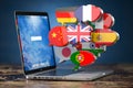 Global communication, dictionary, translating  and learning languages online app concept. Laptop and speech bubbles with flags Royalty Free Stock Photo