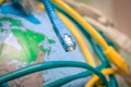 Global Communication Technology. ConceptFiber optic patch cord is close-up on a background of the globe. Different Internet wires Royalty Free Stock Photo