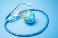 Global environment, planetary health, globe planet and stethoscope on blue background