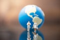 Global healthcare and Covid-19 Concept. Docter and nurse miniature figure people walking with mini world ball as background