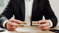 global, local concept. man holds wooden blocks in his hands with inscriptions local and global.