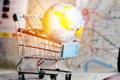 Global map ball America in small shopping cart on tablet. Road m Royalty Free Stock Photo