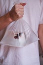 A man holds a fish in a plastic bag close-up