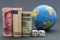 Global risks reflected in three currencies, dice, and globe Royalty Free Stock Photo