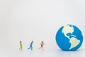 Global sport health concept. Group of runner miniature figure people running to mini world ball on white background with copy