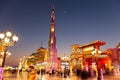 Global Village amusement park at night with illuminated Burj Khalifa miniature and pagodas.