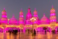 Global Village amusement park at night with pink illuminated arabic style towers and domes.