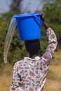 Water scarcity an african girl forced to walk long distances spills water from a bucket