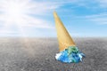 Global Warming and Pollution Concept : Ice cream planet earth melting on asphalt road with blue sky and sunlight in background. Royalty Free Stock Photo