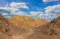 Global warming results of dry wasteland desert landscape with bare sand stone rocks and dunes on blue sky white clouds background Royalty Free Stock Photo