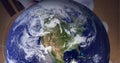 Globe against close up of hand of businessman against grey background