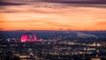 Globe arena building illuminated in pink against sunset sky during Christmas holiday season.